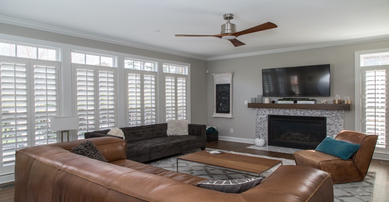 Shutters in a living room with a tv